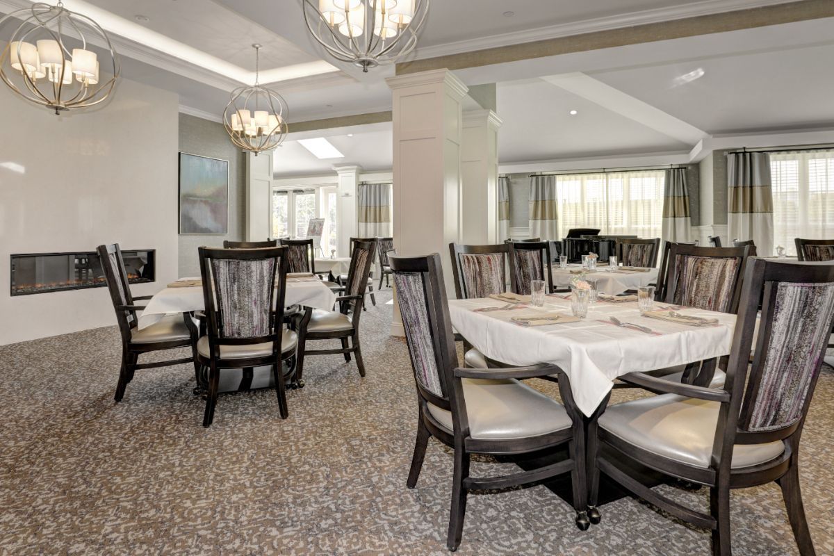 An elegant dining room with beautifully set tables and stylish chandeliers.