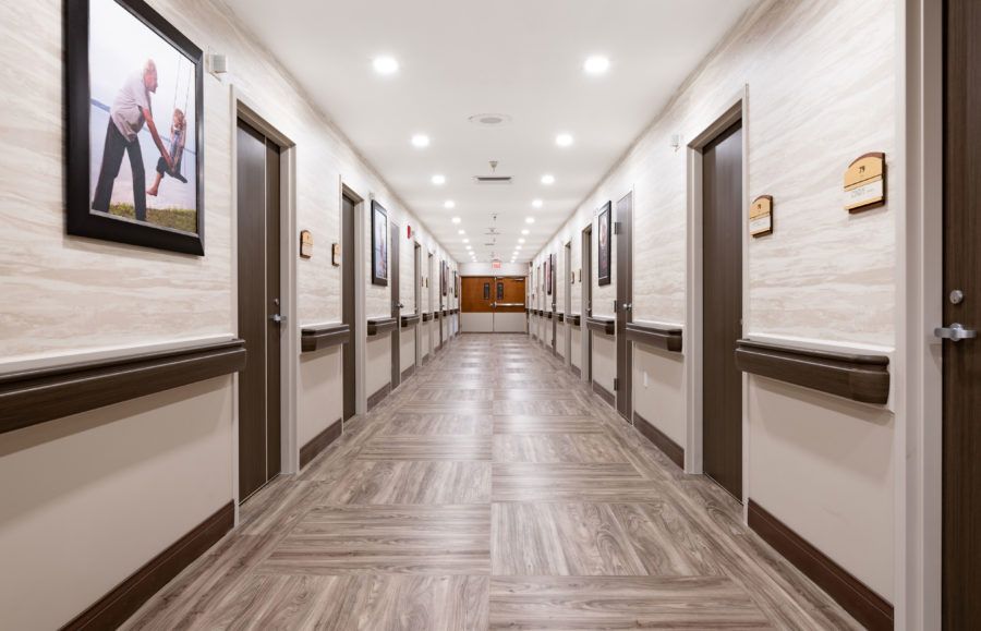 A modern hallway with wooden floors and multiple doors on each side.