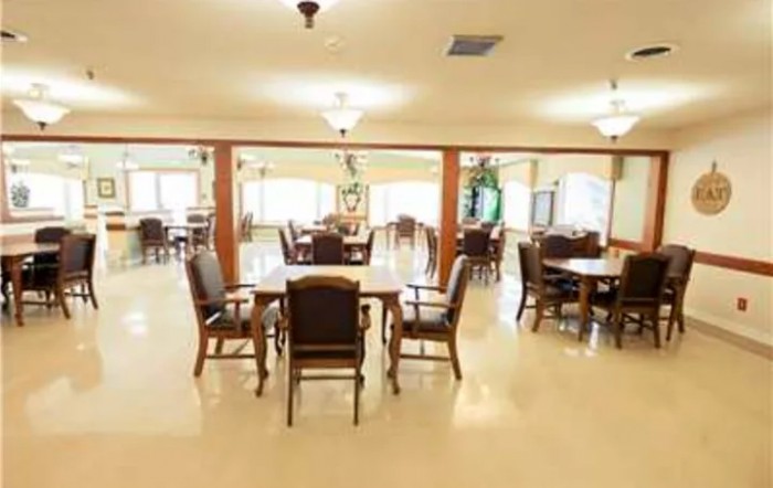 A bright and spacious dining room with several tables and chairs arranged neatly.