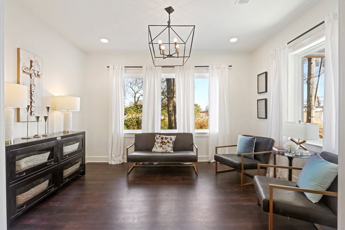 A modern and minimalist living room with ample natural light and stylish furniture.