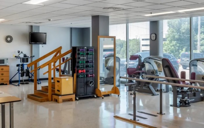 A rehabilitation center with exercise equipment, including stairs and treadmills.