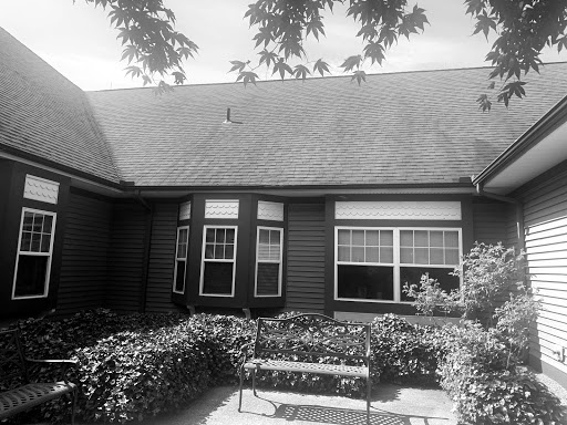 A view of a charming house with a well-kept garden in black and white.