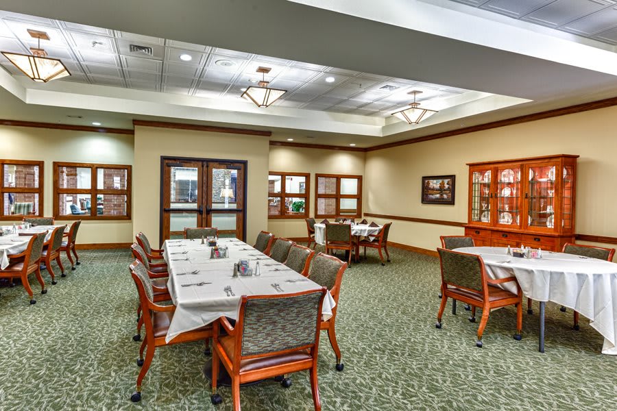 A well-lit dining room with neatly arranged tables and chairs, featuring elegant interior design.