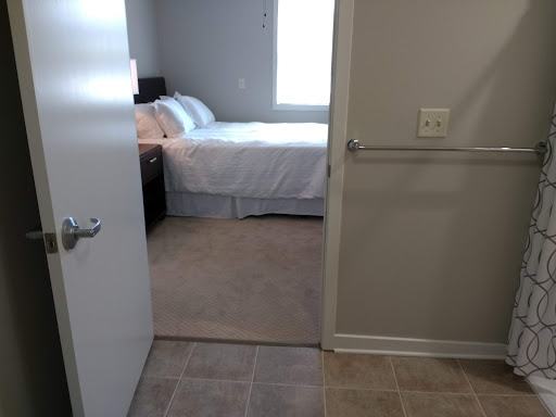 A view from the doorway into a cozy bedroom with a large bed and natural light.