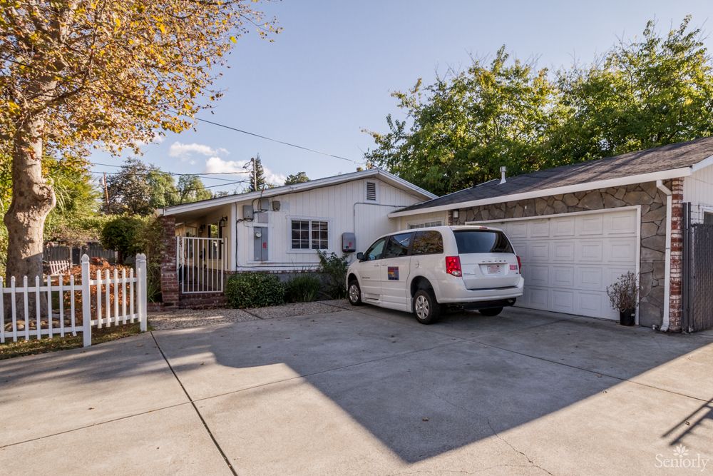 A single-story house with a driveway and a parked van in front of the garage.