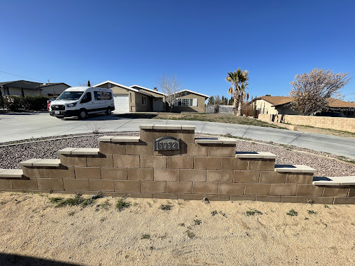 A view of a suburban neighborhood with a driveway and a vehicle parked outside.