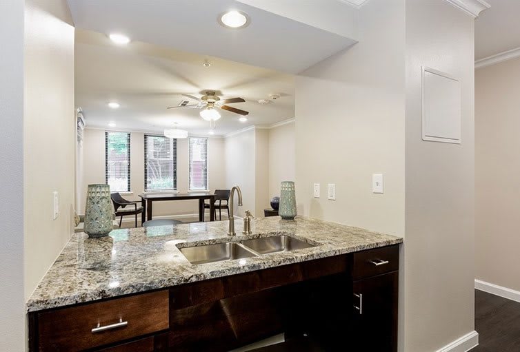 Modern kitchen with granite countertops and open living area.
