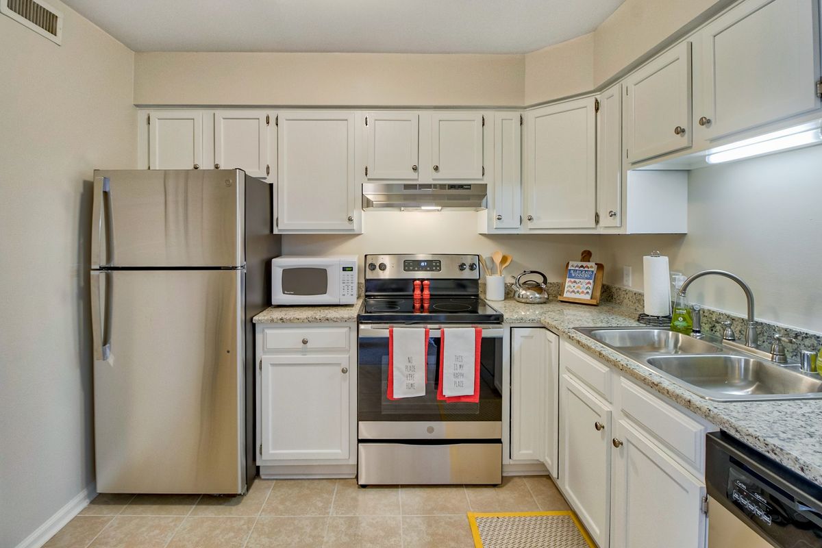 A modern kitchen with stainless steel appliances and white cabinets.