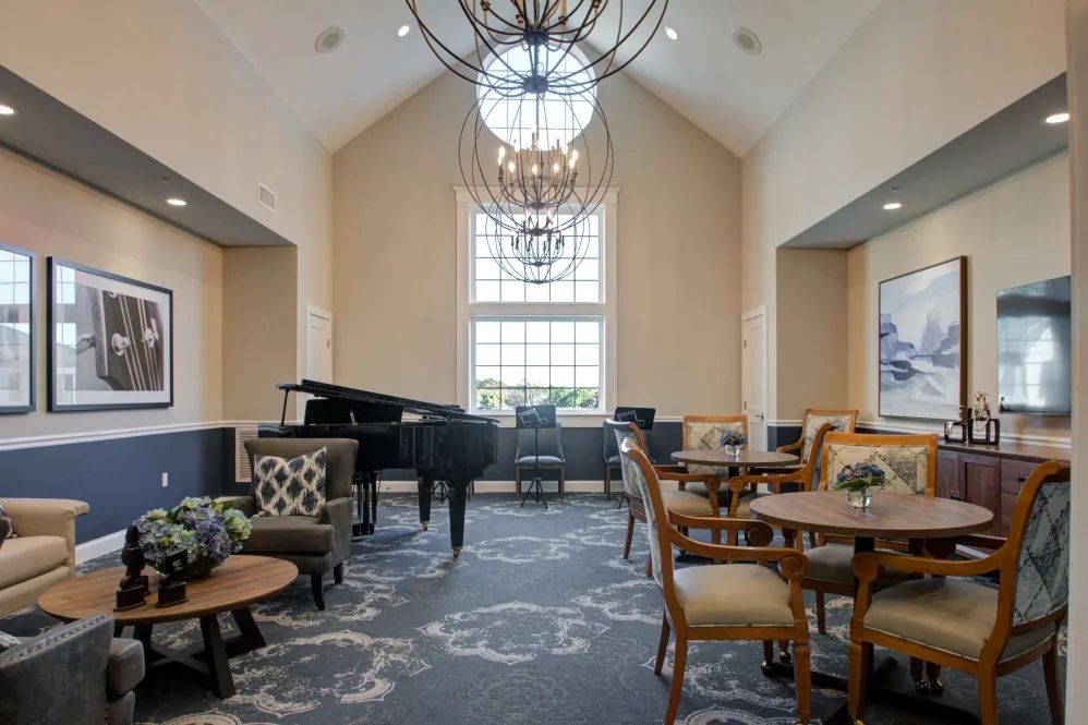 A well-lit lounge area with a grand piano and comfortable seating arrangements.