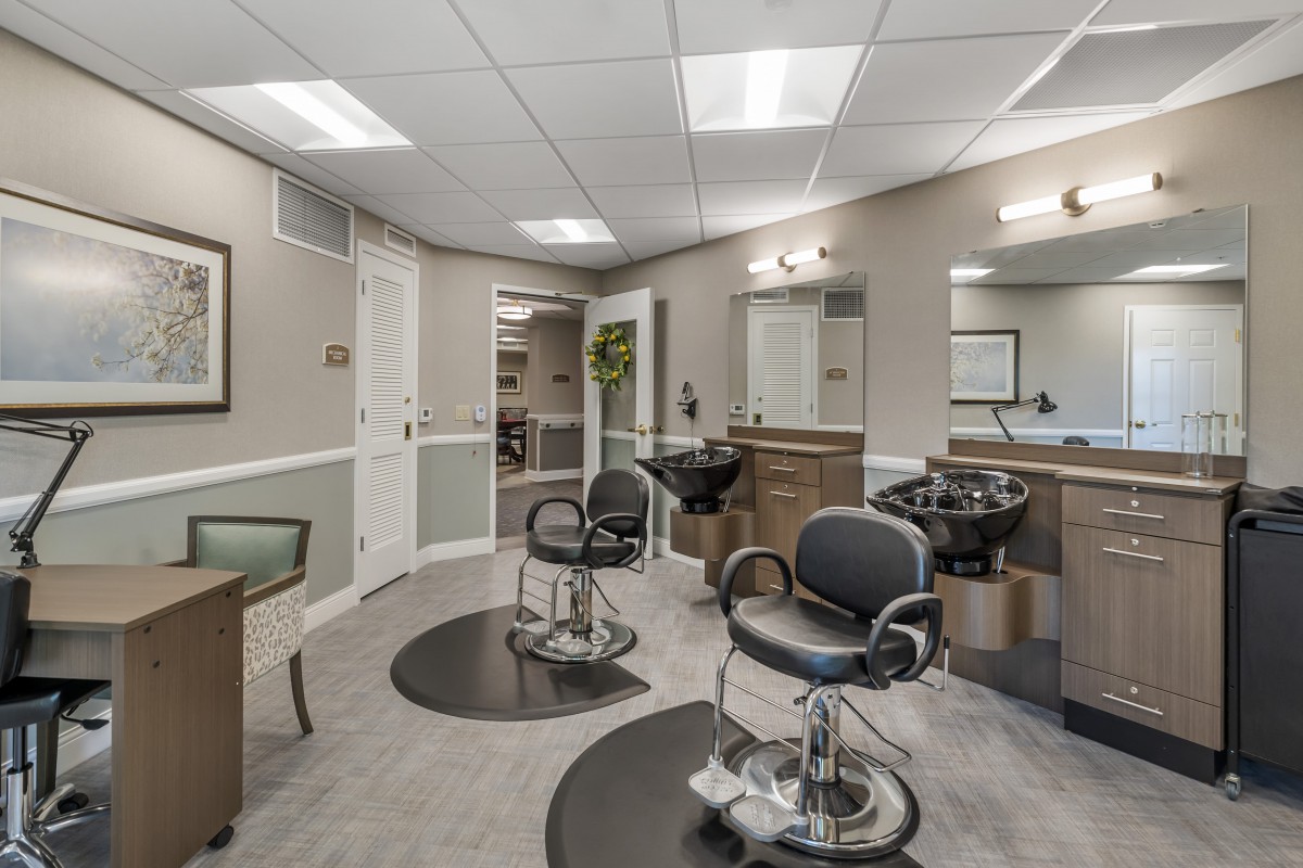 A modern hair salon with multiple barber chairs and mirrors.
