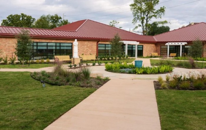 A modern building with a landscaped garden and walkway.