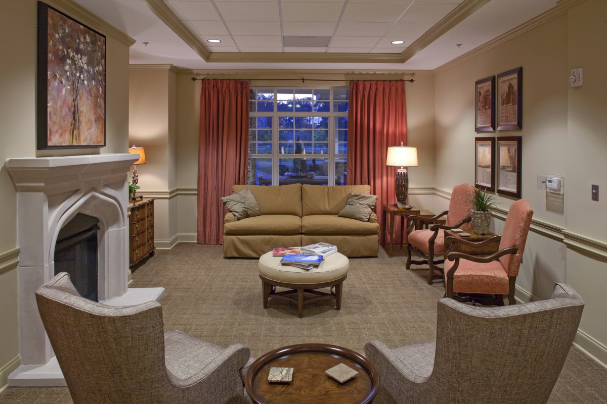 A cozy living room with a sofa, chairs, and warm lighting creating an inviting atmosphere.
