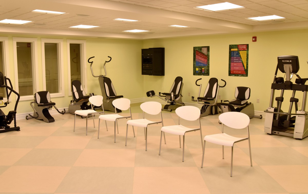 A spacious indoor exercise room with chairs and fitness equipment neatly arranged.