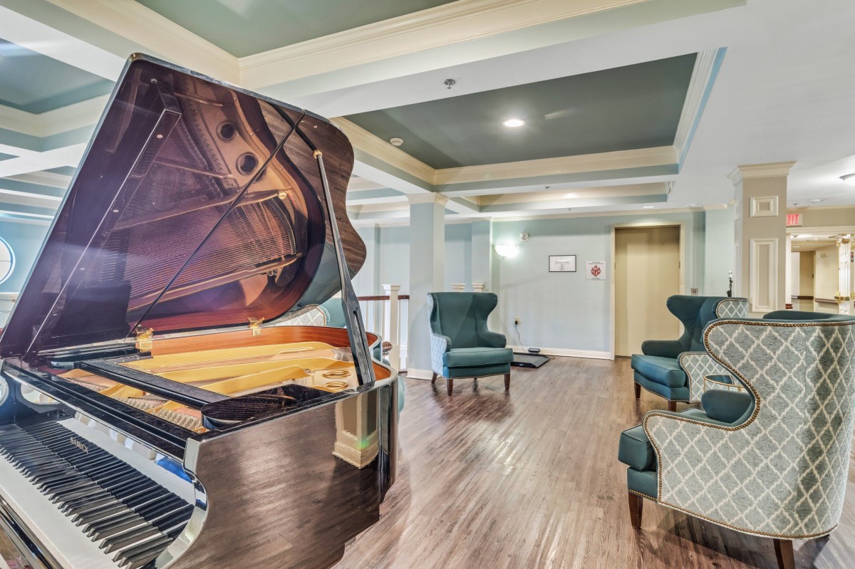 A stylish lounge area featuring a grand piano and comfortable seating.