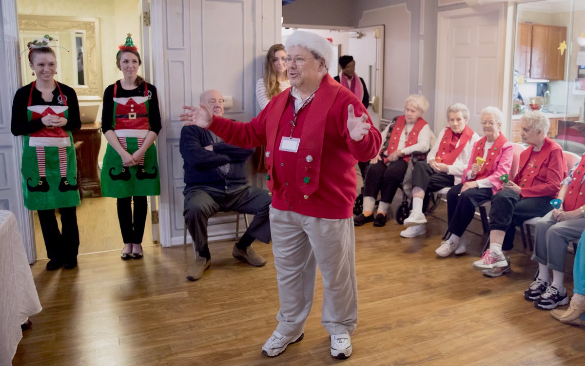 A lively holiday gathering with seniors enjoying festive activities indoors.
