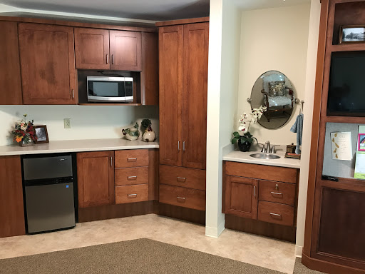 A cozy kitchen featuring wooden cabinets, a countertop, and a microwave.