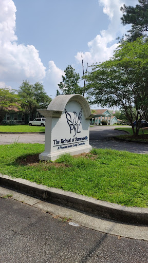 Entrance sign for The Batik & Textiles, set in a green landscape.