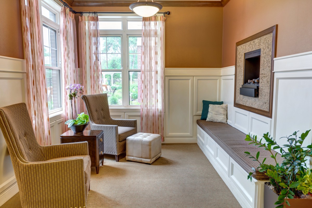 A cozy living room corner with armchairs near a large window, allowing natural light to fill the space.