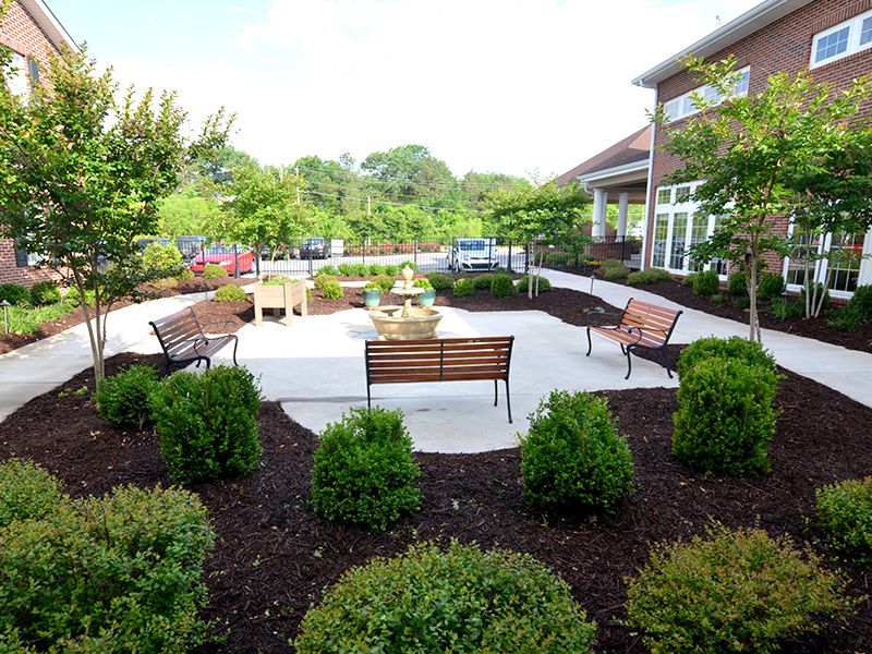 A beautifully landscaped garden with benches and a patio area.