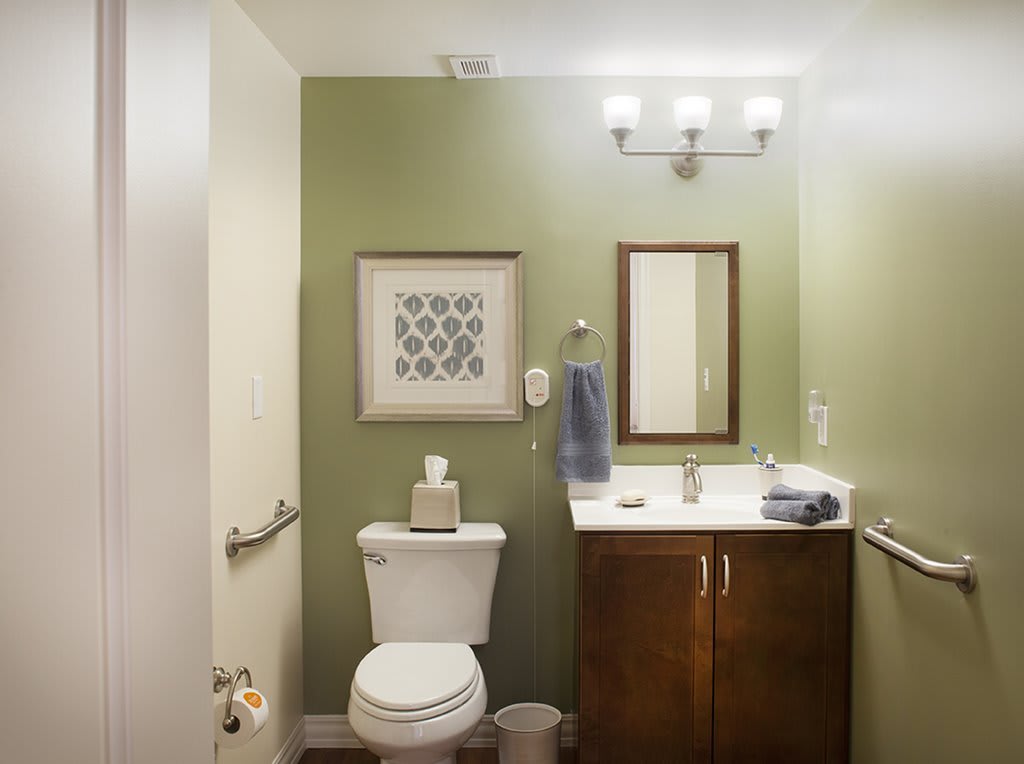 Modern bathroom with a green accent wall and simple decor.