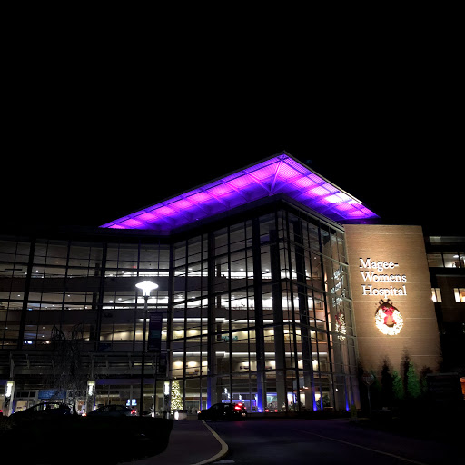 A modern building illuminated with vibrant purple lights at night.