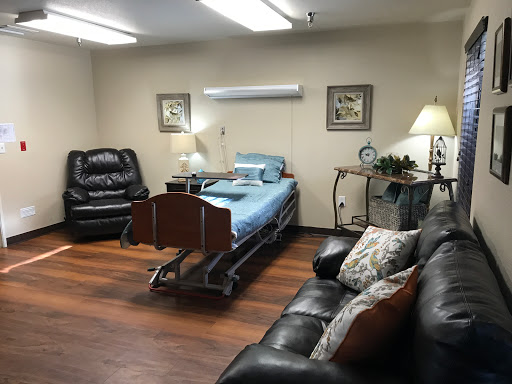 A well-furnished hospital room featuring a bed, comfortable seating, and soft lighting.