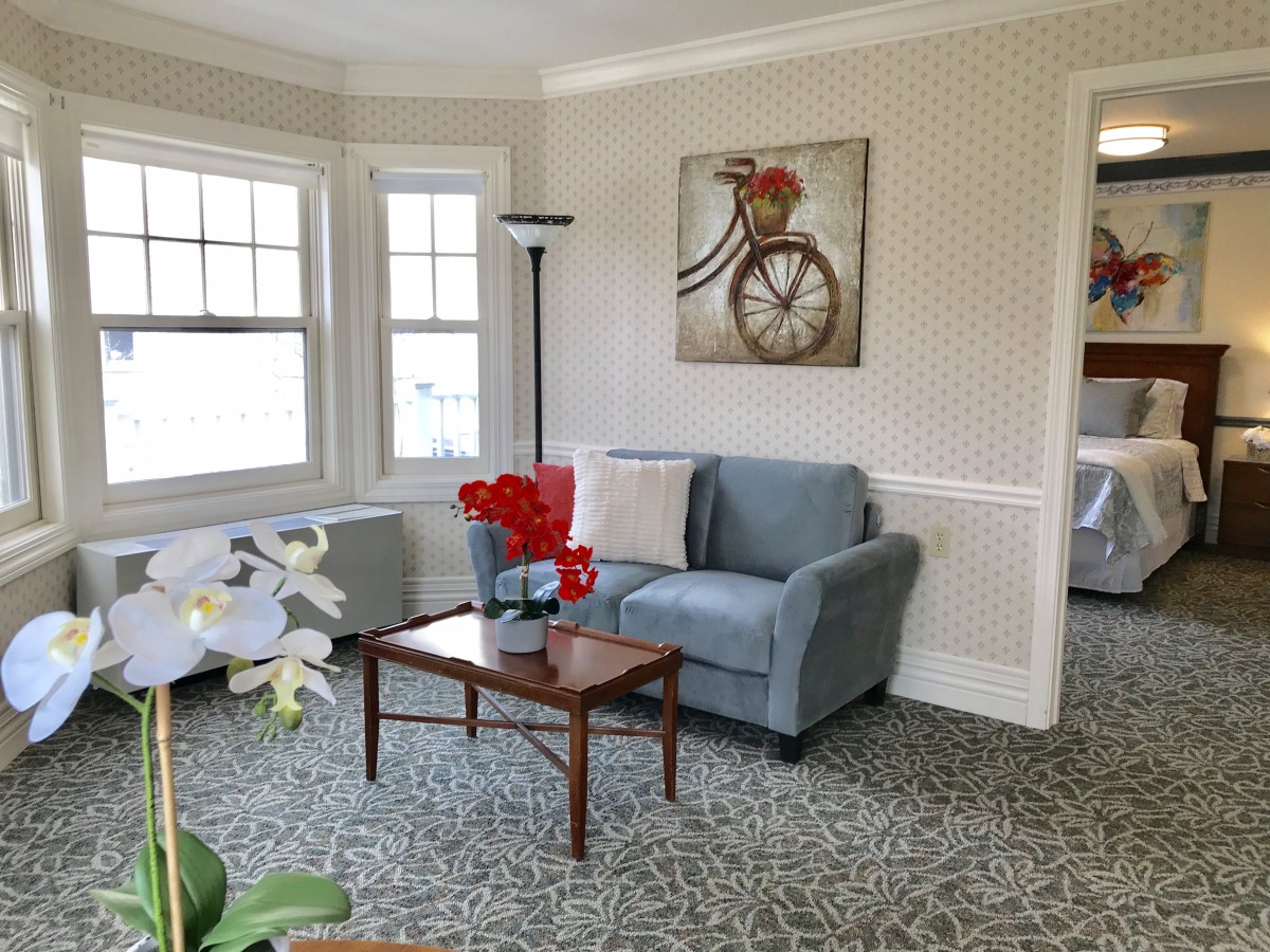 Cozy living room with a blue armchair, coffee table, and wall art featuring a bicycle.