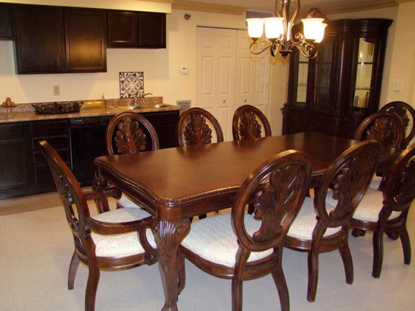 Elegant dining room with a wooden table and chairs under a chandelier.