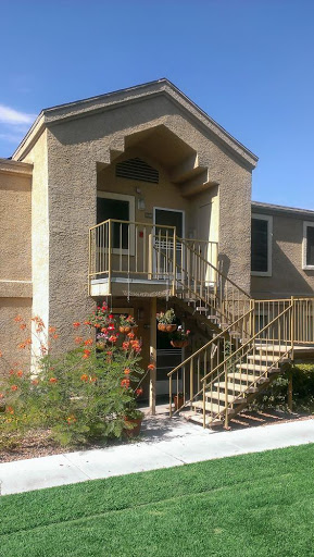 A view of the entrance to a multi-story residential building with an outdoor staircase.