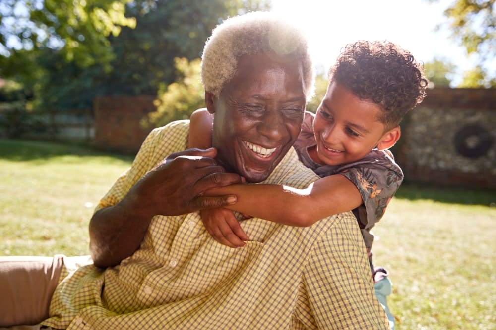 A joyful grandparent and child enjoying a sunny day outdoors.