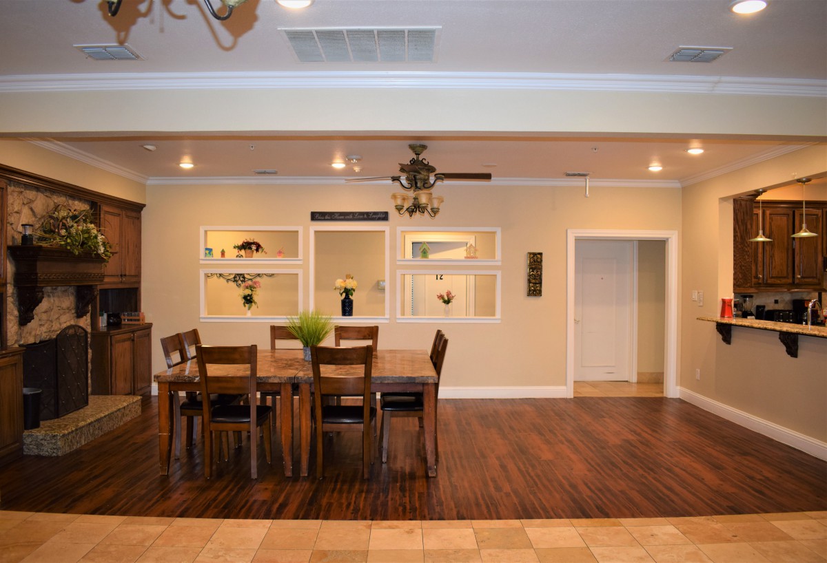 A modern dining room with a wooden table and chairs, featuring wood flooring and stylish decor.
