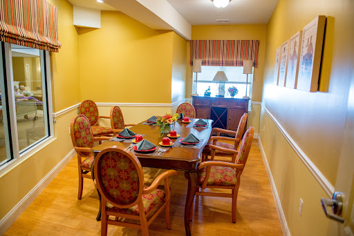 A warmly decorated dining room featuring a wooden table set for a meal, surrounded by comfortable chairs and bright yellow walls.