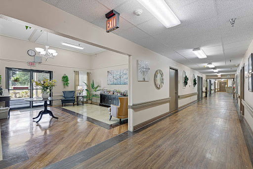 A well-lit hallway in a care facility, featuring decorative elements and comfortable seating.