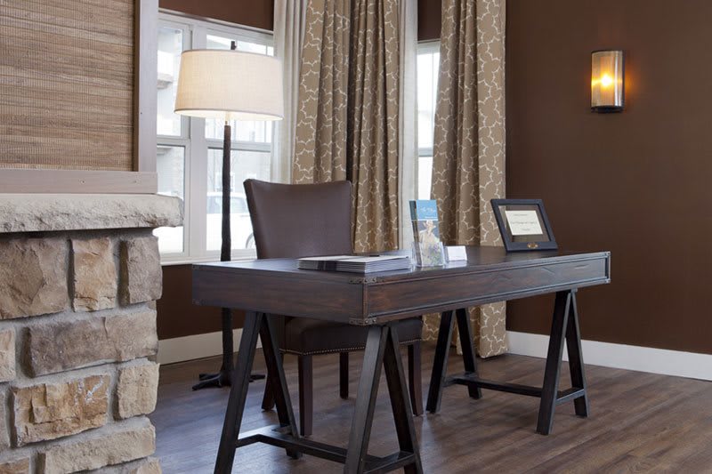 A modern home office with a sleek desk, stylish curtains, and warm lighting.