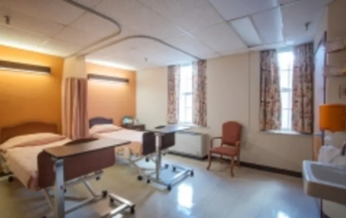 A hospital room featuring a single bed and medical equipment.