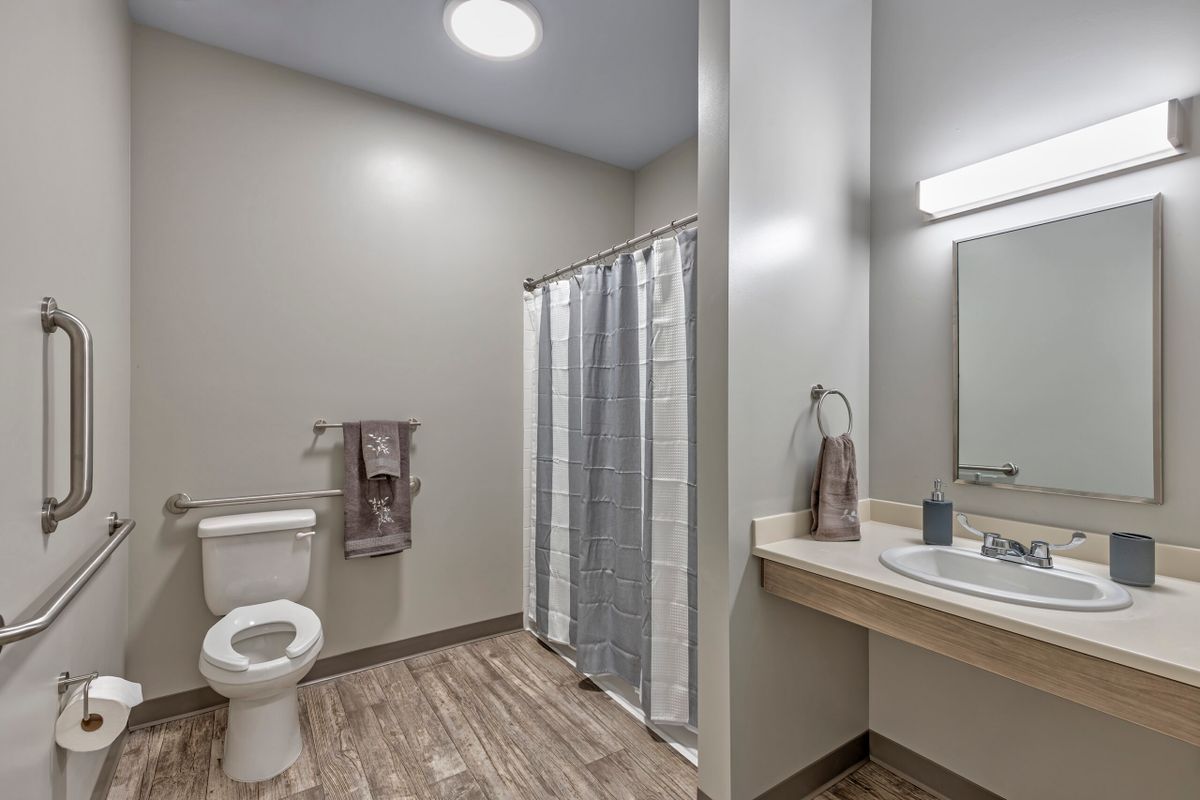 A modern bathroom with a toilet, sink, and shower area.