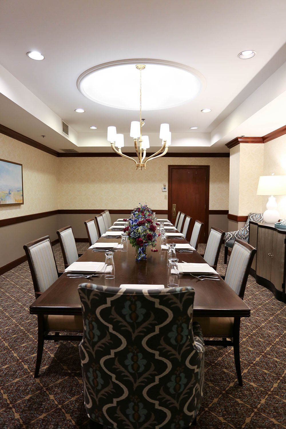 A formal conference room with a long table, set for a meeting.