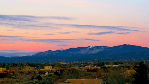 A serene sunset over the mountains, casting a colorful glow in the sky.