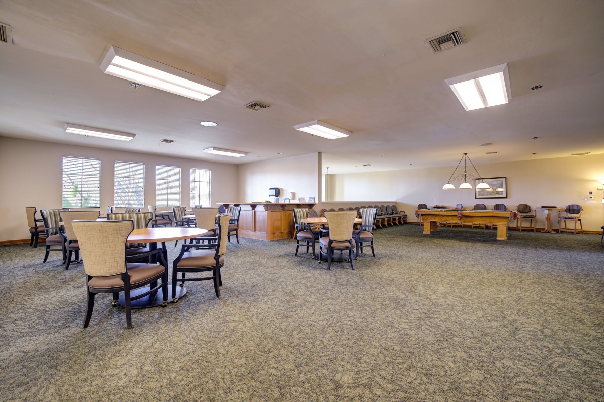 Spacious recreational and dining area with tables and a pool table.