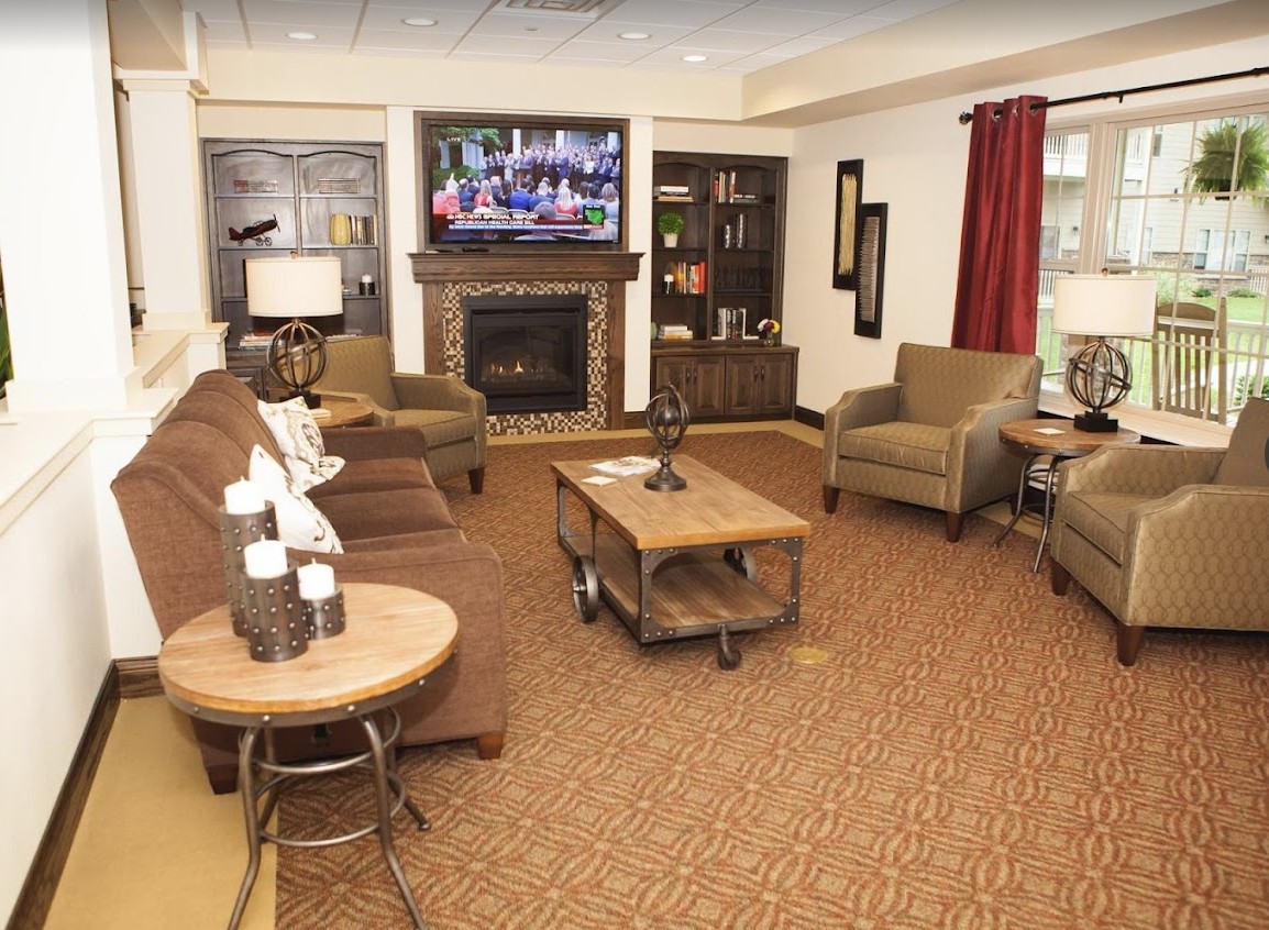 A cozy living room with a fireplace and television, featuring comfortable seating and warm decor.