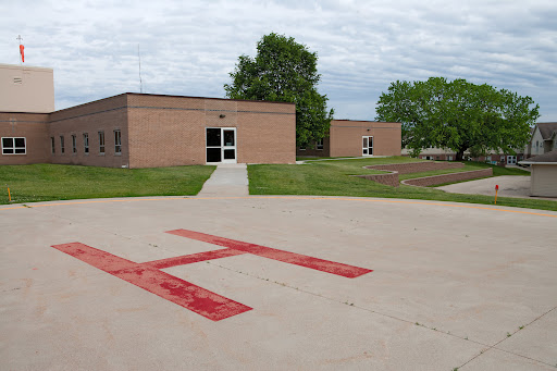 A view of a medical facility featuring a helipad in the foreground.