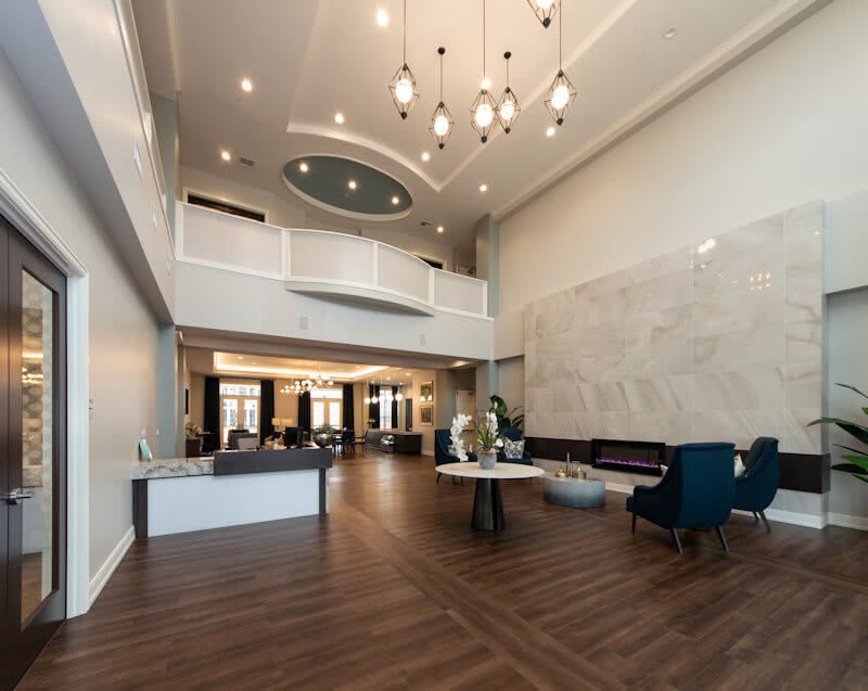 A modern and spacious lobby with elegant chandeliers and comfortable seating.