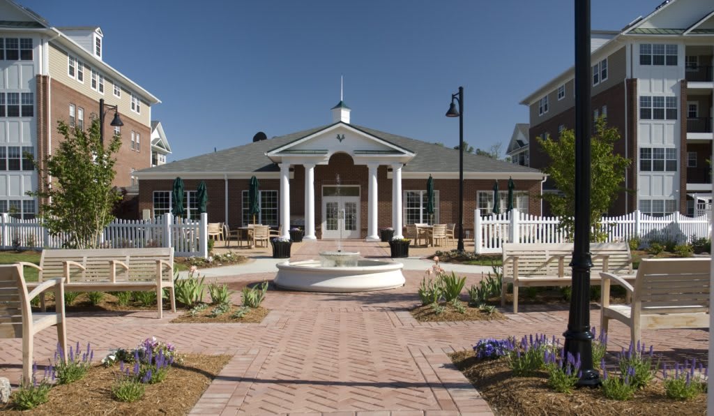A well-maintained building with classical columns and landscaped surroundings on a sunny day.