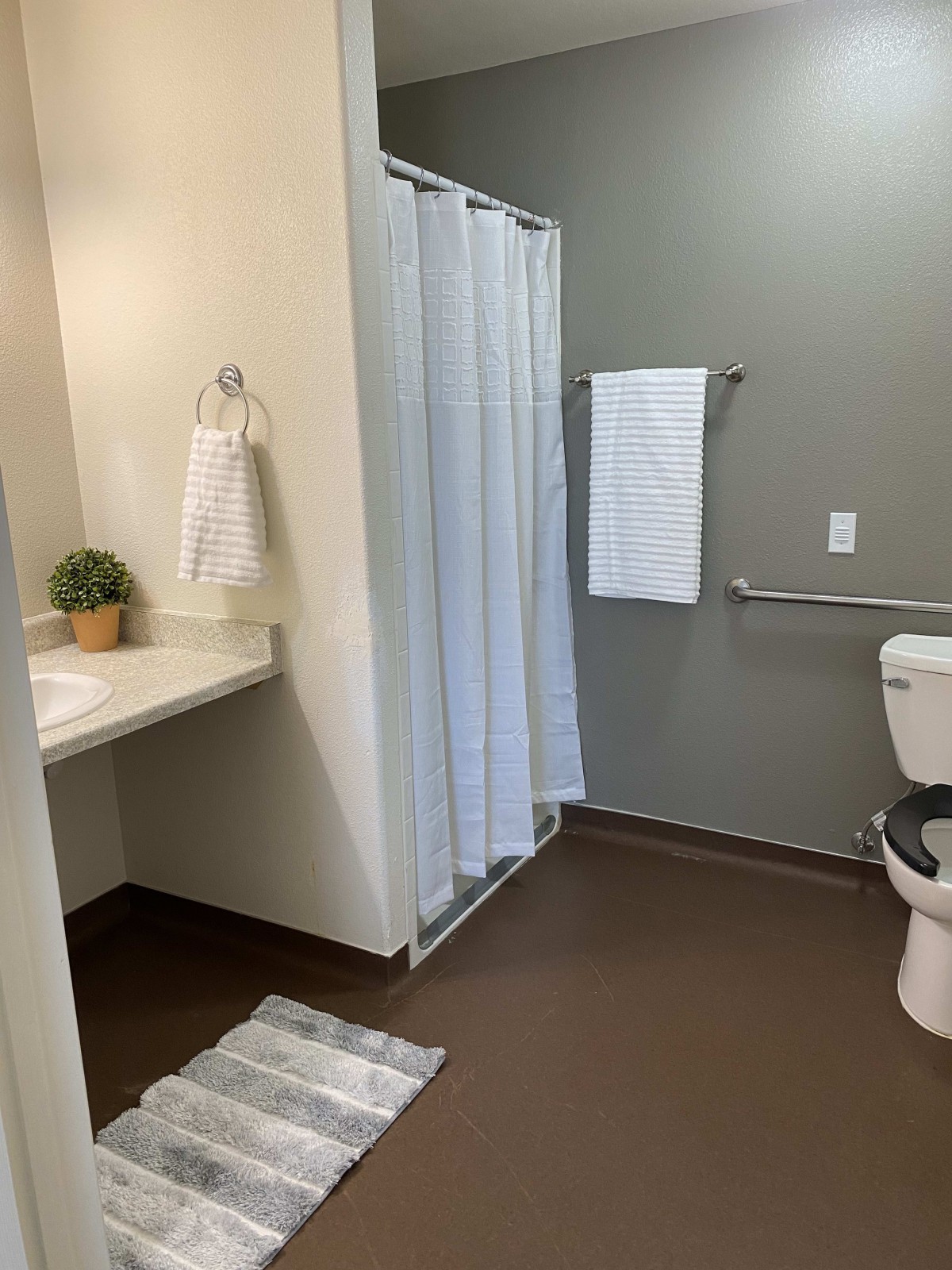 A modern, clean bathroom with a shower, toilet, and sink.