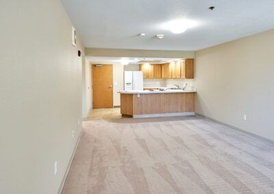 An empty apartment featuring an open floor plan with a kitchen and living room area.