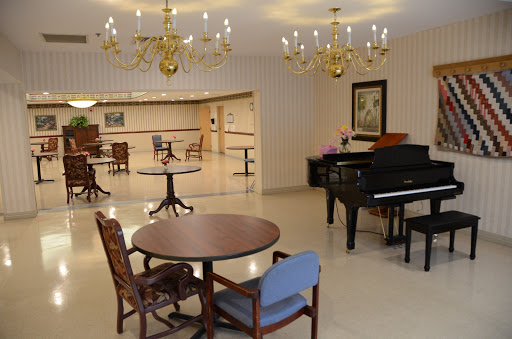A spacious lounge area featuring elegant chandeliers and a piano, designed for relaxation and social gatherings.