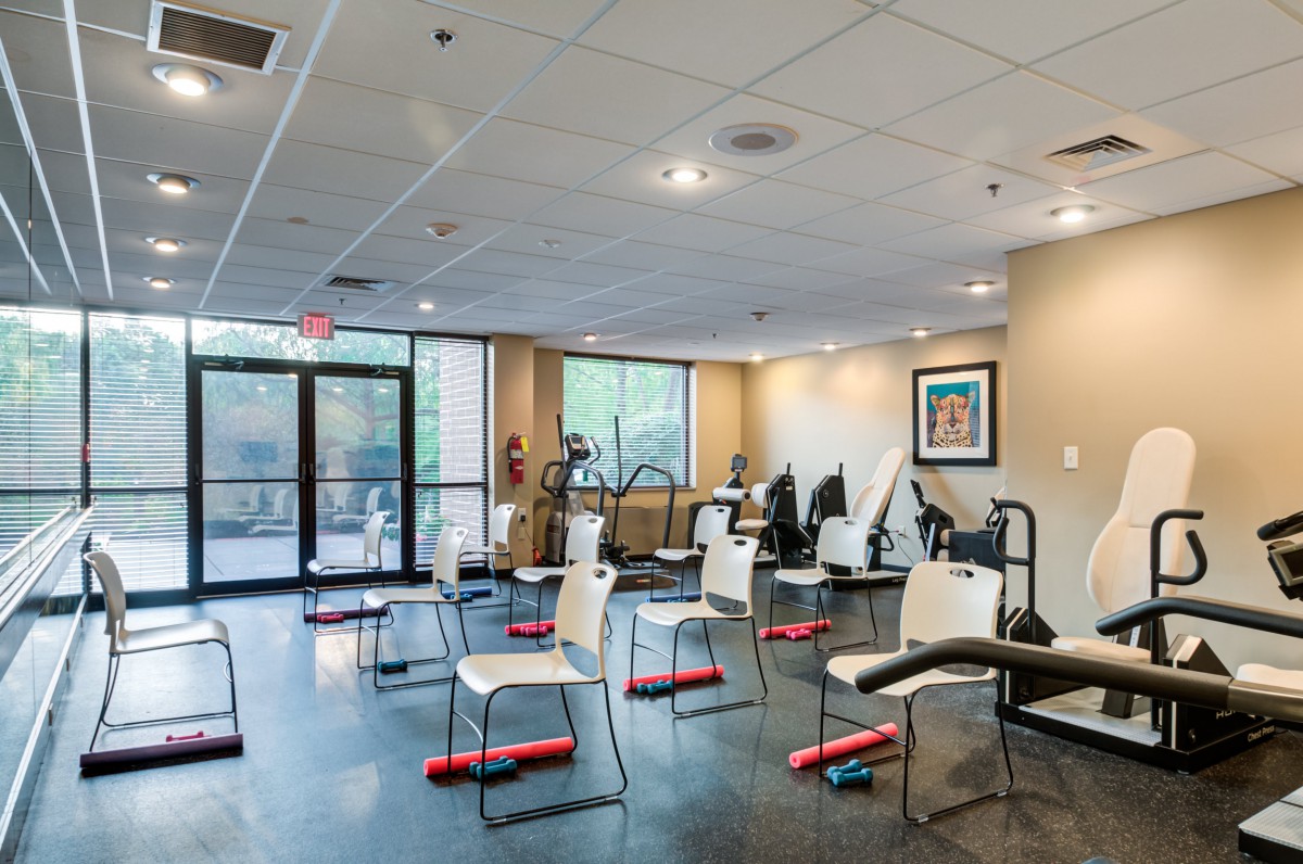 An indoor fitness center with neatly arranged chairs and exercise equipment.