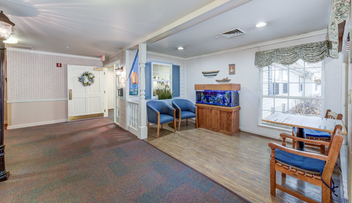 A cozy lobby area with an aquarium, seating, and natural light from windows.