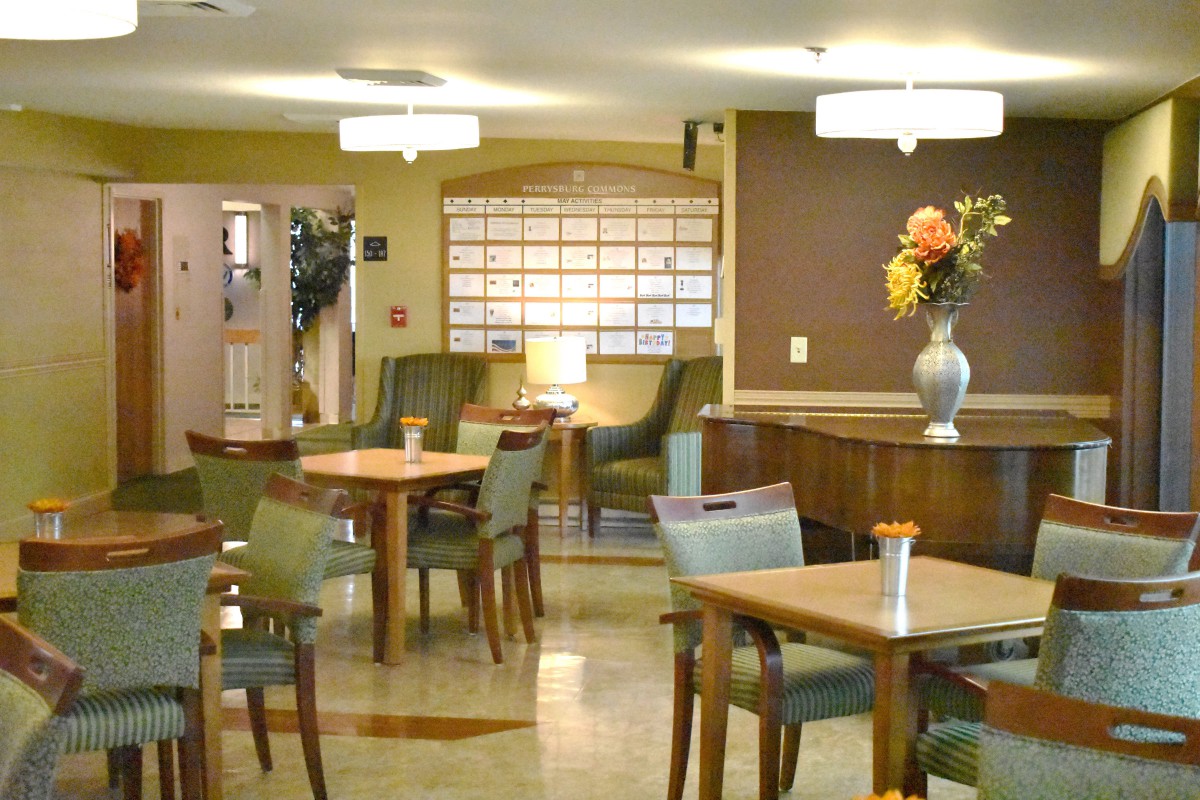 A cozy lounge area featuring tables and chairs, ambient lighting, and a decorative vase with flowers.