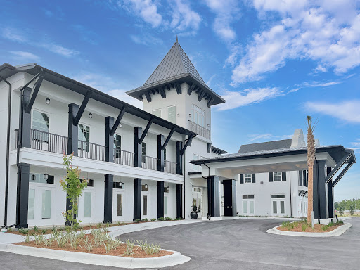 A beautifully designed modern building featuring a unique tower and a spacious courtyard.